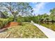 Lush backyard with a chair by the canal and concrete walkway, great for enjoying peaceful waterfront living at 3400 Allapatchee Dr, Punta Gorda, FL 33950