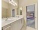 Bright bathroom with double vanity, ample lighting, and a doorway to the bedroom at 4098 Fairway Pl, North Port, FL 34287
