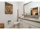 Bathroom features a granite countertop, white cabinets and a decorative mirror at 43050 Greenway Blvd # 645, Punta Gorda, FL 33982