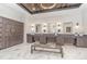 Well-lit locker room featuring wood lockers, marble floors, a bench, and three sinks with modern mirrors at 43050 Greenway Blvd # 645, Punta Gorda, FL 33982