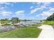 Beautiful pond with a dock, surrounded by lush greenery and a building in the background at 43050 Greenway Blvd # 645, Punta Gorda, FL 33982