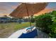 Beautiful backyard features a thatch umbrella, beach chairs, and a waterway view, creating a relaxing waterfront retreat at 48 Hibiscus Dr, Punta Gorda, FL 33950