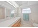 Bathroom featuring a double sink vanity with flamingo art and a tiled shower at 48 Hibiscus Dr, Punta Gorda, FL 33950