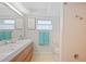 Bathroom featuring a double sink vanity with flamingo art and a tiled shower at 48 Hibiscus Dr, Punta Gorda, FL 33950