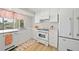 Bright kitchen showcasing white cabinets, classic appliances, and a charming window view at 48 Hibiscus Dr, Punta Gorda, FL 33950