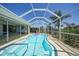 Refreshing pool with an adorable pink flamingo float is surrounded by a screened enclosure, providing a serene outdoor oasis at 48 Hibiscus Dr, Punta Gorda, FL 33950