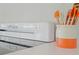 Close-up on the stovetop of the white classic stove and a container of utensils at 48 Hibiscus Dr, Punta Gorda, FL 33950