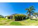 Expansive backyard featuring a screened lanai, lush tropical landscaping, and green lawn at 4992 Brittain Way, North Port, FL 34287