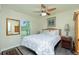 Bedroom with ceiling fan, wood look floors, and a large window providing ample natural light at 4992 Brittain Way, North Port, FL 34287