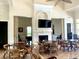Spacious clubhouse interior with tables, chairs, and a cozy fireplace area with a television at 4992 Brittain Way, North Port, FL 34287