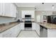 Bright kitchen with stainless steel appliances, white cabinets, granite countertops and tile flooring at 4992 Brittain Way, North Port, FL 34287