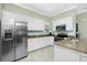 Bright kitchen featuring stainless steel appliances, white cabinets, granite countertops and tile flooring at 4992 Brittain Way, North Port, FL 34287