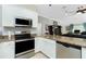 Bright kitchen with stainless steel appliances, granite countertops and easy access to a living room at 4992 Brittain Way, North Port, FL 34287