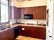 Well-organized kitchen featuring dark wood cabinetry and laminate countertops, illuminated by natural light from a window at 4992 Brittain Way, North Port, FL 34287
