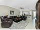 Comfortable living room featuring tile floors, a ceiling fan, and a cozy seating area with leather furniture at 4992 Brittain Way, North Port, FL 34287