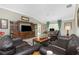 Comfortable living room featuring tile floors, a ceiling fan, and a cozy seating area with leather furniture at 4992 Brittain Way, North Port, FL 34287
