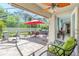 Screened-in patio with brick flooring, ceiling fan, patio set, and hot tub with view to interior living area at 4992 Brittain Way, North Port, FL 34287
