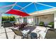 Covered brick patio with outdoor furniture, a grill, a hot tub and plenty of space for relaxing at 4992 Brittain Way, North Port, FL 34287