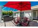 Screened patio with an outdoor dining set and red umbrella, plus a relaxing hot tub for enjoying the Florida lifestyle at 4992 Brittain Way, North Port, FL 34287