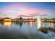 Picturesque pond at dusk with a lit fountain provides a tranquil backdrop to the surrounding homes at 4992 Brittain Way, North Port, FL 34287