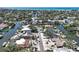 Aerial view of a neighborhood featuring waterfront homes, canals, mature trees, and city skyline in the distance at 5181 Sandy Shore Ave, Sarasota, FL 34242
