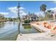 Waterfront backyard featuring a boat dock, canal access, and lush tropical landscaping for added privacy at 5181 Sandy Shore Ave, Sarasota, FL 34242