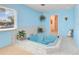 A bright blue bathroom showcasing a jacuzzi tub surrounded by tile and illuminated by natural light at 5181 Sandy Shore Ave, Sarasota, FL 34242