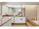 A bathroom featuring a double sink vanity, a large mirror, and patterned wall and floor tiles at 5181 Sandy Shore Ave, Sarasota, FL 34242