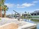Backyard dock overlooking a canal, featuring a boat lift, and neighborhood views with mature palm trees at 5181 Sandy Shore Ave, Sarasota, FL 34242