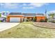 Charming single-story home featuring an attached garage, well-maintained lawn, and beautiful landscaping at 5181 Sandy Shore Ave, Sarasota, FL 34242
