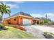 A spacious house with an attached garage, lush landscaping and a beautifully maintained lawn on a sunny day at 5181 Sandy Shore Ave, Sarasota, FL 34242
