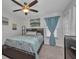 Bright bedroom with a ceiling fan, a comfortable bed with blue patterned bedding and plenty of natural light at 526 Allen St, Punta Gorda, FL 33950