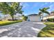 Home with a long driveway, a two-car garage, mature trees, and well-maintained landscaping at 526 Allen St, Punta Gorda, FL 33950