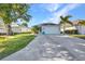 Home with a long driveway, a two-car garage, mature trees, and well-maintained landscaping at 526 Allen St, Punta Gorda, FL 33950