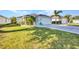 Well-maintained home featuring a two-car garage, lush lawn, and a charming blue chair near the driveway at 526 Allen St, Punta Gorda, FL 33950