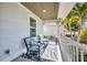 Relaxing covered porch with seating area, decorated with an ocean theme rug and a view of palm trees at 526 Allen St, Punta Gorda, FL 33950