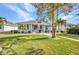 Charming single-story home boasts a manicured lawn, walkway, mature trees, and covered porch seating at 526 Allen St, Punta Gorda, FL 33950