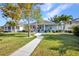 Charming single-story home boasts a manicured lawn, walkway, mature trees, and covered porch seating at 526 Allen St, Punta Gorda, FL 33950