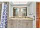 Bathroom features a granite countertop with double sinks and a shower with blue patterned shower curtain at 80 Hibiscus Dr, Punta Gorda, FL 33950