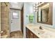 Well-lit bathroom with a granite countertop vanity and tiled flooring, plus access to the outside at 80 Hibiscus Dr, Punta Gorda, FL 33950