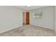 This carpeted bedroom includes a window and a closet with a wooden door at 80 Hibiscus Dr, Punta Gorda, FL 33950