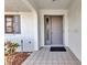 Exterior entryway featuring an arched doorway, tiled porch, and neutral-toned front door with sidelight at 80 Hibiscus Dr, Punta Gorda, FL 33950