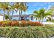 Beautifully landscaped home with vibrant flowers, lush greenery, and mature palm trees, creating a welcoming curb appeal at 80 Hibiscus Dr, Punta Gorda, FL 33950