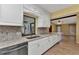 Bright kitchen featuring white cabinetry, granite countertops, stainless steel appliances, and a breakfast bar at 80 Hibiscus Dr, Punta Gorda, FL 33950