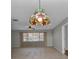 Open living room with a decorative pendant light, ceiling fan, tile flooring, and view of a large window at 80 Hibiscus Dr, Punta Gorda, FL 33950