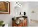 Bathroom featuring a round mirror, black granite vanity, wood cabinets, and tile flooring at 95 N Marion Ct # 135, Punta Gorda, FL 33950