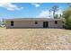 A spacious backyard with a house featuring windows and a sliding glass door at 105 Biscayne Dr, Port Charlotte, FL 33953