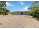 Expansive backyard featuring a sliding glass door entry, set against a bright sky at 105 Biscayne Dr, Port Charlotte, FL 33953
