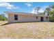 Large backyard featuring a house with modern windows, and sliding glass door access at 105 Biscayne Dr, Port Charlotte, FL 33953