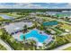 Aerial view of community pool, tennis court, bocce ball, and clubhouse in a beautifully landscaped setting at 1132 Moss Cove Ct, Port Charlotte, FL 33953